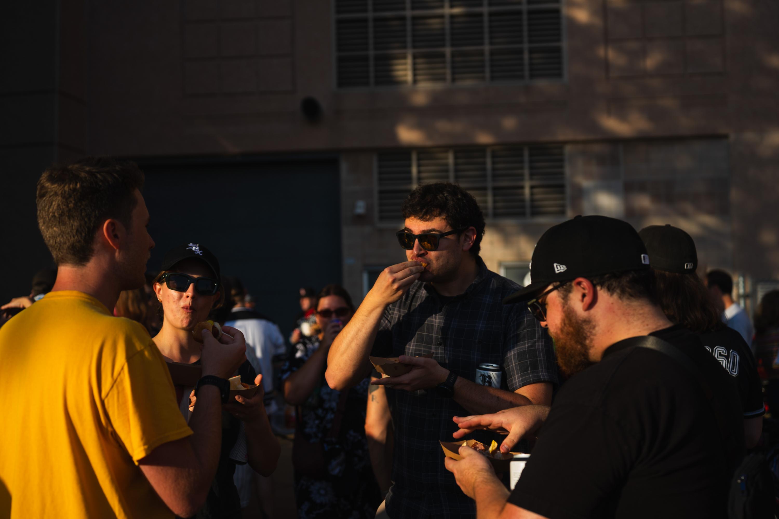 Bikers eat bratwursts while chatting before the Chicago Sox game against the Texas Rangers. Aug. 25, 2026.